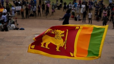 Sri Lanka Economic Crisis: A Sri Lankan flag is waved by a protester. (AP) Sri Lanka Economic Crisis: A Sri Lankan flag is waved by a protester. (AP)