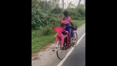 A screengrab from the viral video shared by Harsh Goenka. It shows the woman riding a cycle with her child in the makeshift backseat.&nbsp; (Twitter/@hvgoenka)