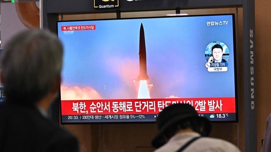 People watch a television screen showing a news broadcast with file footage of a North Korean missile test, at a railway station in Seoul.(AFP)