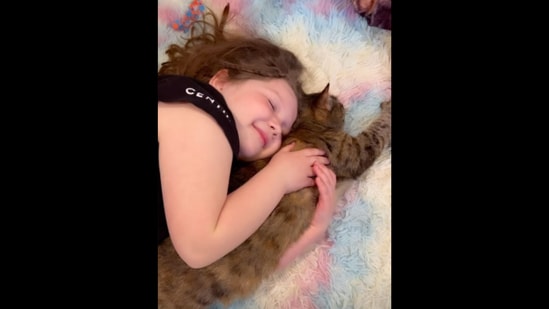 The little girl can be seen snuggling with her pet cat.&nbsp;(Instagram/@joyandtreasure)