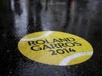 A rain-covered sticker of a tennis ball shows the way to walk towards the French Open tennis tournament outside the Roland Garros stadium, in Paris. A light drizzle is expected top cause delays in the first round matches. (AP Photo/Peter Dejong)