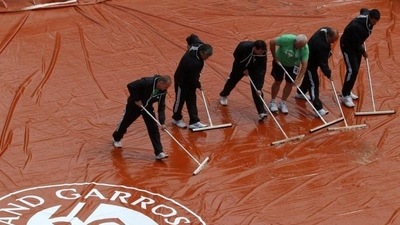 Stadium employees wipe the protective canvas on center court after rain delayed the play for the first round match of the French Open tennis tournament at the Roland Garros stadium, in Paris (AP Photo) Stadium employees wipe the protective canvas on center court after rain delayed the play for the first round match of the French Open tennis tournament at the Roland Garros stadium, in Paris (AP Photo)