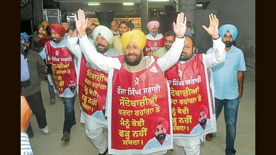 Congress MLAs walk into the Punjab assembly wearing aprons demanding action against cabinet minister Fauja Singh Sarari over the alleged extortion plan audio clip. (Ravi Kumar/HT)