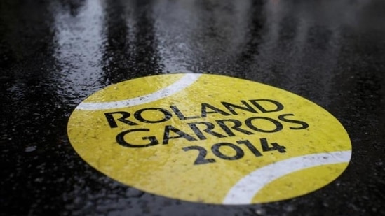 A rain-covered sticker of a tennis ball shows the way to walk towards the French Open tennis tournament outside the Roland Garros stadium, in Paris. A light drizzle is expected top cause delays in the first round matches. (AP Photo/Peter Dejong)
