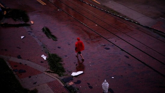 Hurricane Ian Hits Florida: A man walks among fallen palm leaves and debris in a street as Hurricane Ian makes landfall in southwestern Florida.(Reuters)