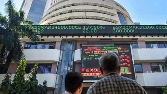 ht newलोग मुंबई में बॉम्बे स्टॉक एक्सचेंज (बीएसई) के बाहर एक स्क्रीन पर सेंसेक्स देखते हैं। (पीटीआई फाइल फोटो) ht newलोग मुंबई में बॉम्बे स्टॉक एक्सचेंज (बीएसई) के बाहर एक स्क्रीन पर सेंसेक्स देखते हैं। (पीटीआई फाइल फोटो)