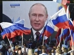 People watch on a large screen as Russian President Vladimir Putin delivers his speech after a ceremony to sign the treaties for four regions of Ukraine to join Russia in Kremlin.(AP) People watch on a large screen as Russian President Vladimir Putin delivers his speech after a ceremony to sign the treaties for four regions of Ukraine to join Russia in Kremlin.(AP)