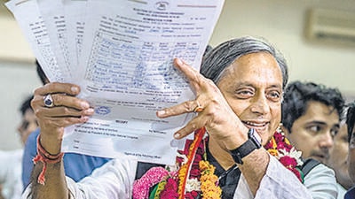 Former Union minister Shashi Tharoor shows his documents as he files his nomination papers for Congress party president election at AICC headquarters in New Delhi on Friday. (AP) Former Union minister Shashi Tharoor shows his documents as he files his nomination papers for Congress party president election at AICC headquarters in New Delhi on Friday. (AP)
