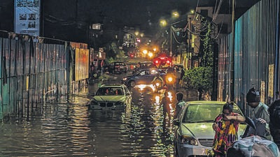 A car stuckin a watterlogged road at Lohegaon road in Pune. (Shankar Narayan/HT PHOTO)