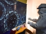 Covid Cases In India: An illustration of the novel coronavirus seen next to a health care worker at a Covid-19 testing centre in New Delhi.