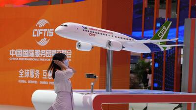 A woman stands near a model of China's domestically made C919 passenger jet during the China International Fair for Trade in Services (CIFTIS) in Beijing, on September 1, 2022. (AP) A woman stands near a model of China's domestically made C919 passenger jet during the China International Fair for Trade in Services (CIFTIS) in Beijing, on September 1, 2022. (AP)