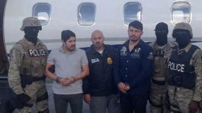 Efrain Antonio Campo Flores (2nd from L) and Franqui Fancisco Flores de Freitas stand with law enforcement officers in this November 12, 2015 photo after their arrest in Port Au Prince, Haiti.&nbsp; (Reuters)