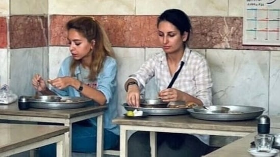 An image posted on the Twitter account of Donya Rad on September 28, 2022, shows her (R) and a friend eating at a cafe in the capital Tehran .(AFP)