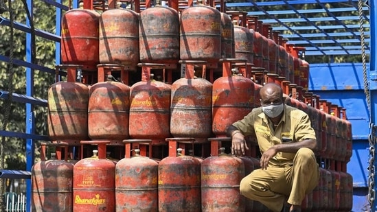 A worker sits inside a lorry, stacked with LPG cylinders . (PTI file)