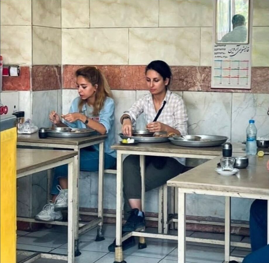 An image posted on the Twitter account of Donya Rad on September 28, 2022, shows her (R) and a friend eating at a cafe in the capital Tehran . (AFP)