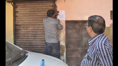 An ADA staff pasting a notice for closing business activities on a closed shop in Tajganj locality of Agra. (HT photo) An ADA staff pasting a notice for closing business activities on a closed shop in Tajganj locality of Agra. (HT photo)