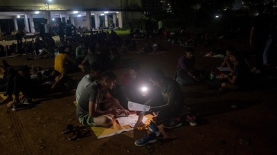 Candidates seen working on recruitment forms in the dark, outside a school in Thane, on September 29. Those who make it through the physical test have to undergo a medical examination followed by a written exam. (Satish Bate / HT Photo)