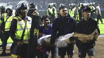 Football fans carry an injured man following clashes during a match at Kanjuruhan Stadium in Malang, East Java, Indonesia (AP) Football fans carry an injured man following clashes during a match at Kanjuruhan Stadium in Malang, East Java, Indonesia (AP)