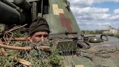 Russia-Ukraine War: A Ukrainian soldier looks out from a tank, amid Russia's invasion of Ukraine, in the frontline city of Lyman, Donetsk region, Ukraine. (Reuters)