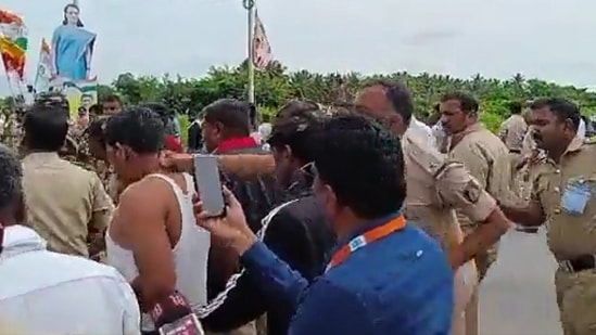 A police officer punching the Congress worker for wearing PayCM t-shirt