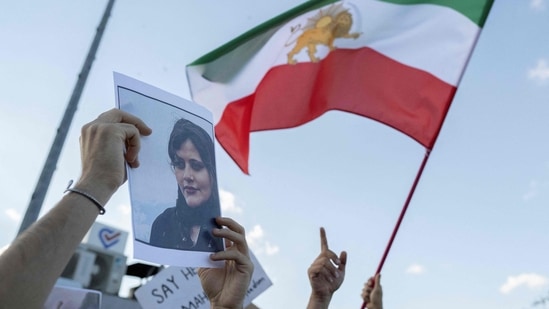 Iran Anti-Hijab Protests: A protestors holds a photo of Mahsa Amini.(AFP)