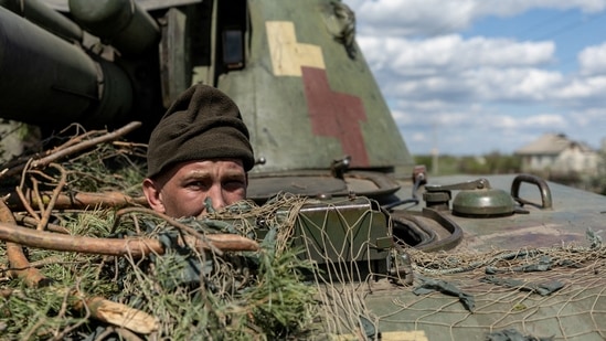 Russia-Ukraine War: A Ukrainian soldier looks out from a tank, amid Russia's invasion of Ukraine, in the frontline city of Lyman, Donetsk region, Ukraine.(Reuters)