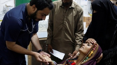 Pakistan Floods: Naveed Ahmed, 30, a doctor, gives medical assistance to flood-affected woman Koonjh, 25, who is suffering from fever in Sehwan, Pakistan. (Reuters)