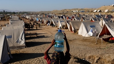 Pakistan Floods: A displaced girl carries a bottle of water she filled from nearby stranded flood-waters in Sehwan, Pakistan. (Reuters)