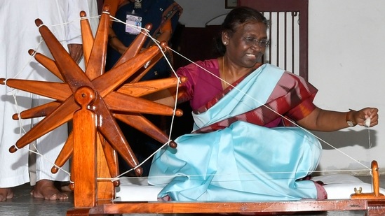 President Droupadi Murmu spins a charkha at the Ashram.(@rashtrapatibhvn) President Droupadi Murmu spins a charkha at the Ashram.(@rashtrapatibhvn)
