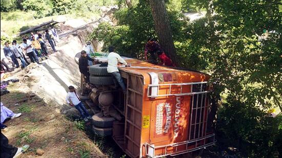 People gather near a passenger bus after it overturned, in Udhampur on Monday. (ANI)