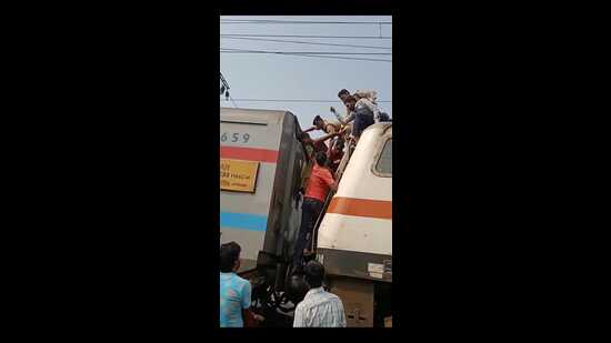 The mentally unwell youth being rescued from atop the engine of the Pawan Express in Prayagraj on Monday. (HT PHOTO)