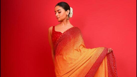 Alia Bhatt looks ethereal in a yellow and red dual ombre-toned bandhani saree. 