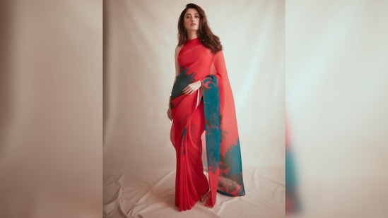 Tamannaah Bhatia paired her contemporary saree with a solid red halter neck blouse.(Instagram/@tamannaahspeaks)