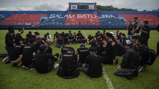 Indonesia Stadium Stampede: Players and officials from Arema Football Club gather to pray on the pitch for victims of the stampede at Kanjuruhan stadium in Malang, East Java. (AFP)