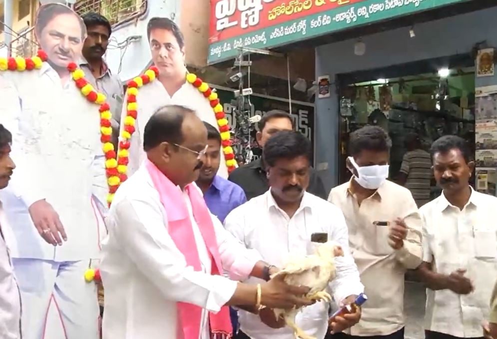 Video grab of TRS leader Rajanala Srihari distributing liquor and chicken to locals in Warangal. (ANI Twitter)