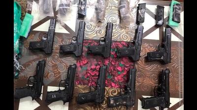 Police recovered 10 foreign-made pistols, including five .30 bore (made in China) and five 9mm (made in USA Beretta), along with eight spare magazines from the two arrested for cross-border arms smuggling. (HT Photo)