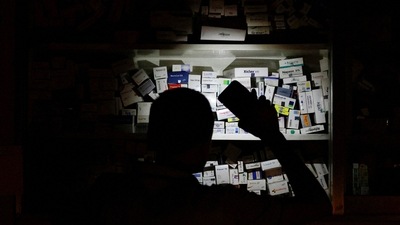 Bangladesh Blackout: A salesman of a pharmaceutical shop uses his cellphone torch to find medicine in Dhaka, Bangladesh. (Reuters)