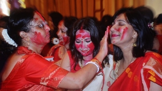 बंगाली महिलाओं ने बुधवार को मुंबई के ठाणे में इस साल दुर्गा मां को विदाई देते हुए सिंदूर खेला। भले ही कई अभियानों ने सिंदूर खेला को सभी लिंगों के लिए खुला और अधिक समावेशी बनाने के लिए कहा है, यह मुख्य रूप से विवाहित महिलाओं के बीच एक प्रथा बनी हुई है। (प्रफुल गंगुरडे / एचटी फोटो)