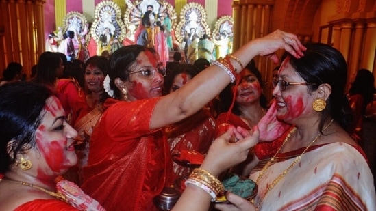On the day of Vijaya Dashami, married women bid farewell to Durga Maa for this year and smear the face of the idol with vermillion. Then they play with vermillion by smearing the faces of other married women.(Praful Gangurde / HT Photo)