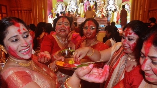 माना जाता है कि सिंदूर खेला दुर्गा पूजा जितनी पुरानी परंपरा है। जमींदारी परिवारों में उनके घर दुर्गा पूजा के दौरान एक अनुष्ठान के रूप में जो शुरू हुआ, वह दुनिया भर में एक प्रथा बन गया। (प्रफुल गंगुरडे / एचटी फोटो)