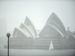 Australia Floods: A yacht sails next to the Opera House while it rains in Sydney.(AFP) Australia Floods: A yacht sails next to the Opera House while it rains in Sydney.(AFP)