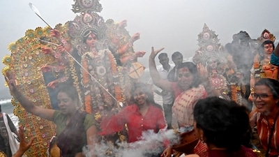 During the day, women participated in the traditional 'Sindoor Khela' (smearing vermilion on each other's faces) and offered sweets and prayers to the goddess before bidding her farewell for the year. (AFP) During the day, women participated in the traditional 'Sindoor Khela' (smearing vermilion on each other's faces) and offered sweets and prayers to the goddess before bidding her farewell for the year. (AFP)