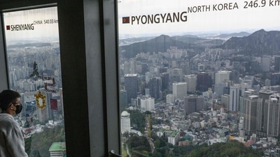 North Korea: A man looks at the view near a window (R) displaying the distance to the North Korean capital, Pyongyang, at the landmark Namsan Tower in Seoul. (AFP)