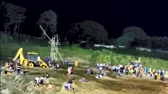 Rescuers attempt to stop people from getting swept in flash floods in the Mal river, in Jalpaiguri district on Wednesday. (PTI)