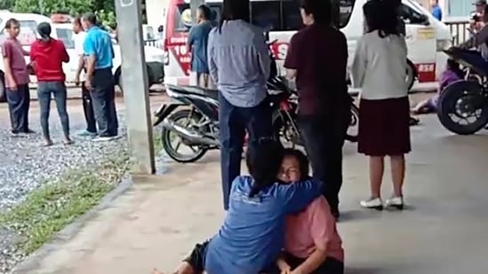 Tiroteio na creche da Tailândia: uma mulher perturbada é consolada do lado de fora do local de um ataque em uma creche, (AP)