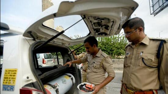 Cops inspect a car for smuggled liquor in Noida. (Sunil Ghosh/ HT)