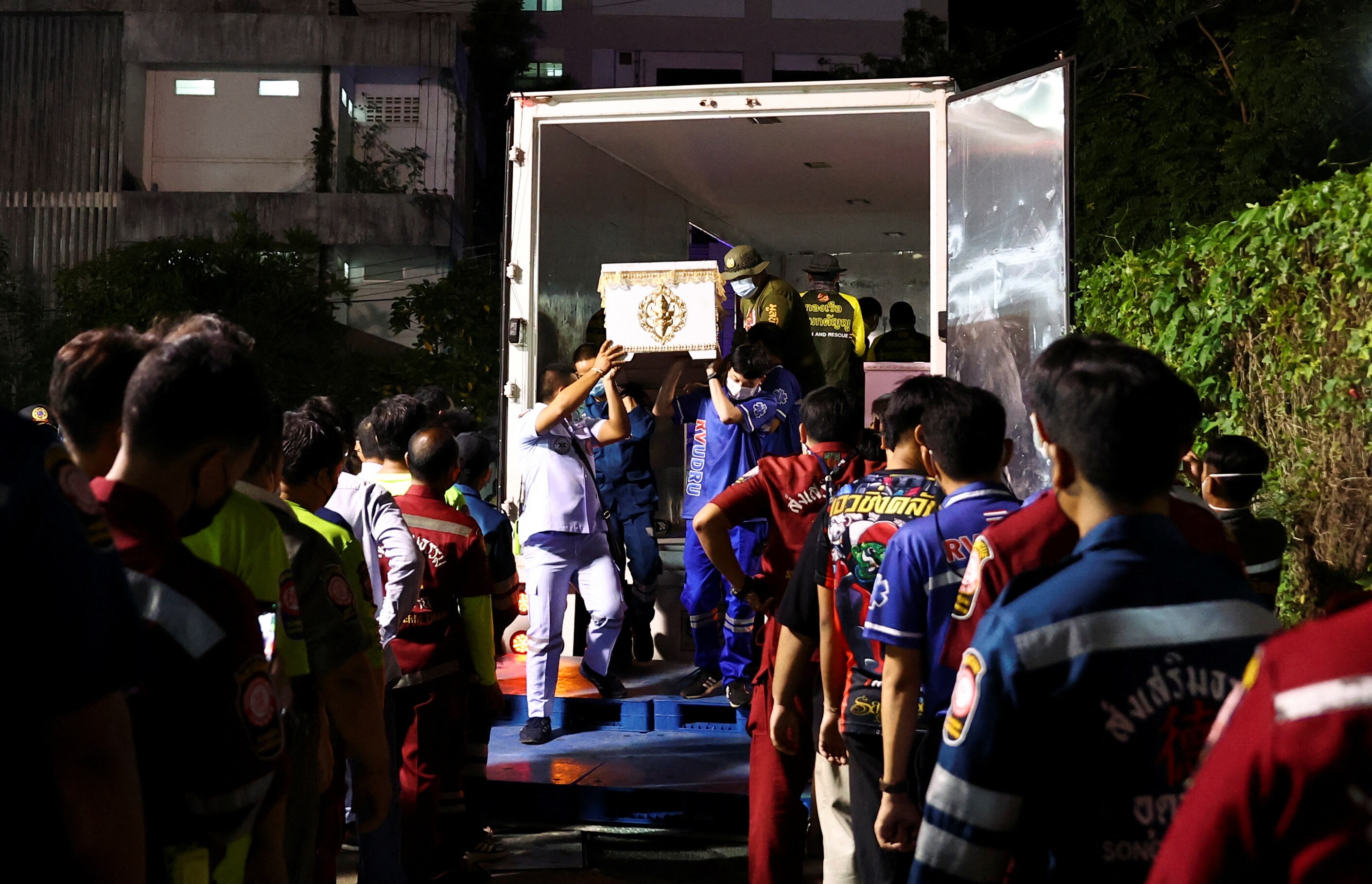 Rescue workers carry coffins containing the bodies of victims at Udon Thani hospital in Udon Thani province, following a mass shooting in the town of Uthai Sawan, Thailand, October 7, 2022. (REUTERS/Athit Perawongmetha)