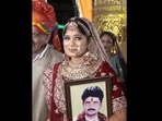 The bride was seen holding her late father's portrait. The bride was seen holding her late father's portrait.