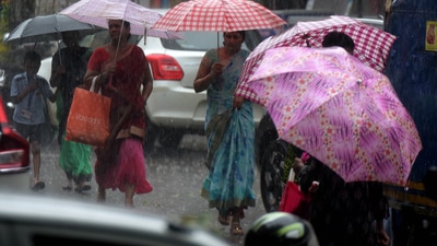 Pedestrians walk in heavy rain holding their umrellas, at Koparkhairane Market, in Navi Mumbai on Friday. (HT Photo/Bachchan Kumar)