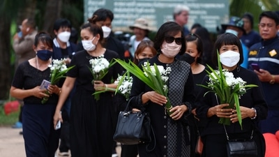 Women carrying floral tributes walk outside the day care centre in the town of Uthai Sawan, around 500 km northeast of Bangkok, in the province of Nong Bua Lam Phu, Thailand. (REUTERS)